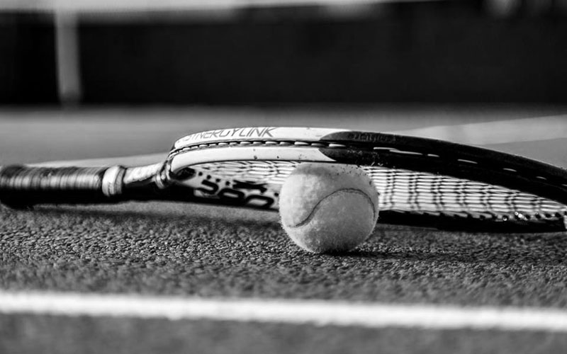 Raqueta con pelota sobre imagen en blanco y negro